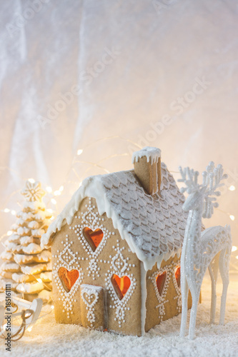 Obraz na płótnie Gingerbread house, Christmas trees and a figure of a deer on a luminous background. Bokeh effect. w salonie