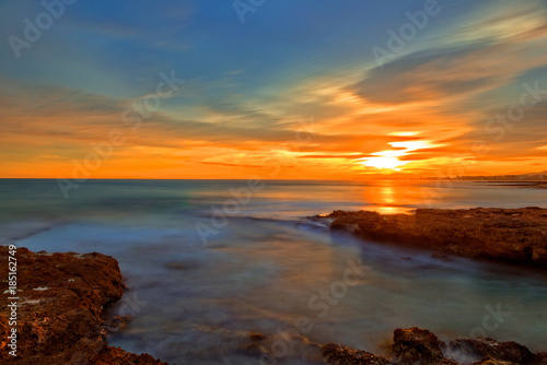 The calm sea in a very cloudy sunset