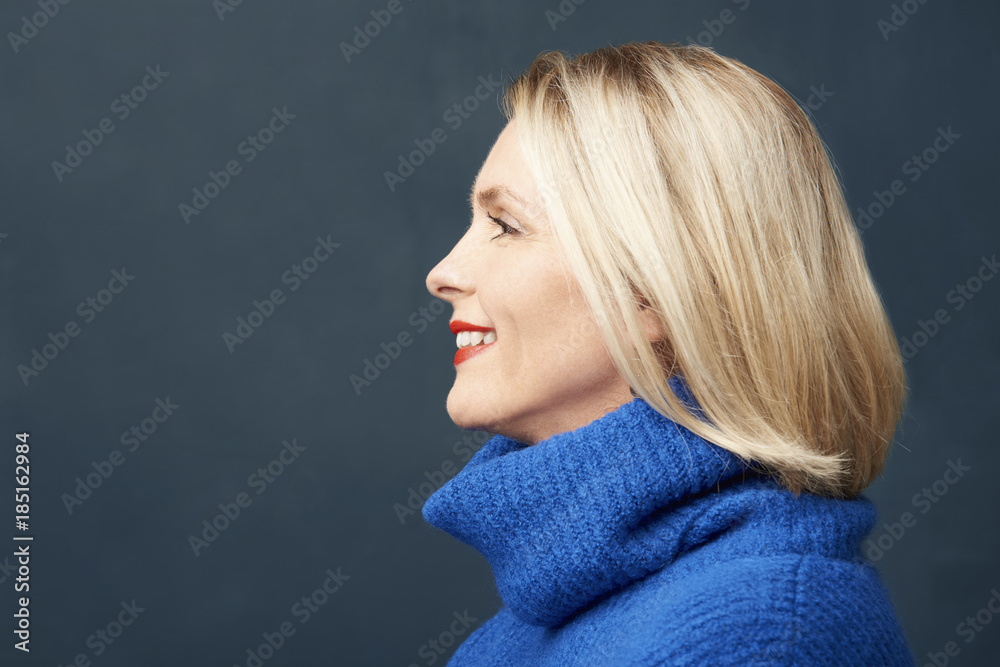 Obraz premium Radiant aging. Face profil studio shot a beautiful elderly woman standing at dark background and smiling