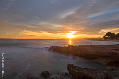 The calm sea in a very cloudy sunset