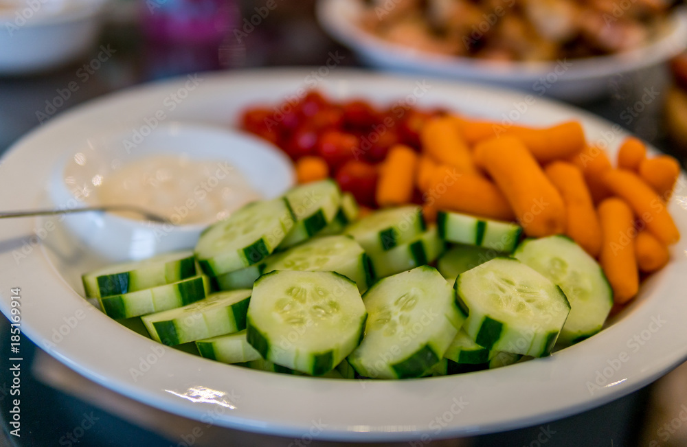 Vegetables and dip on a white round plate Vegetables and dip on a white round plate