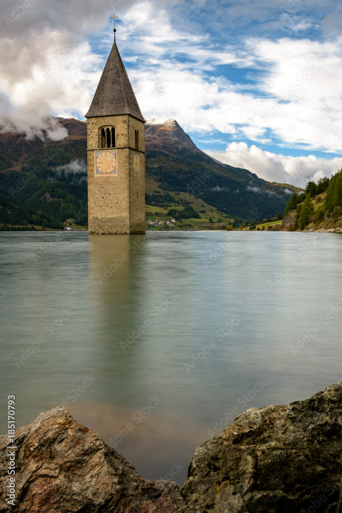Sunk church in lake with mountain panorama.