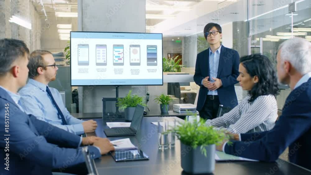 Asian Mobile App Developer Shows Presentation of His New Application Design on a Wall TV Screen to the Investors. Shot on RED EPIC-W 8K Helium Cinema Camera.