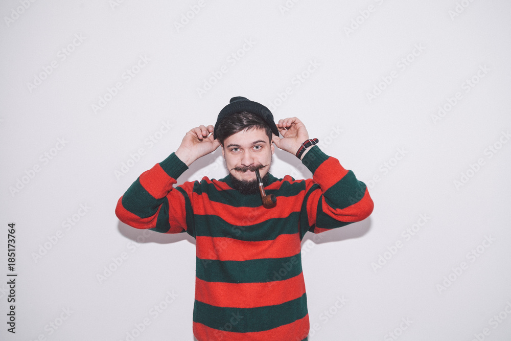 boy wearing bobble hat and smoking tobacco pipe boy wearing bobble hat and smoking tobacco pipe