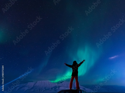 The polar arctic Northern lights aurora borealis sky star in Norway Svalbard man in Longyearbyen city the moon mountains
