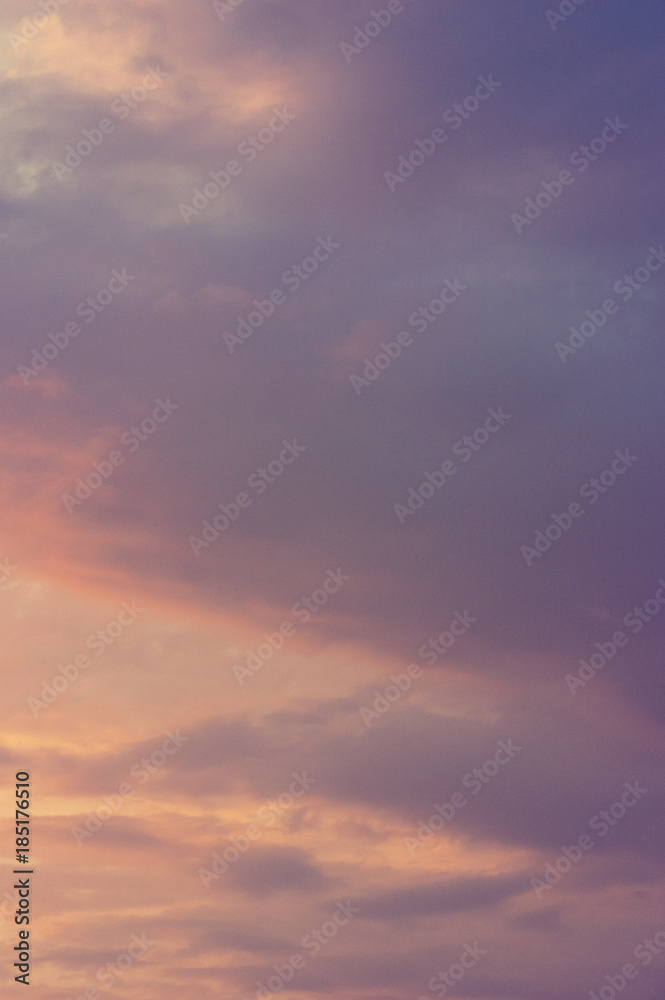 The vertical view of sky background or texture at the sunset time with clouds. Copy space