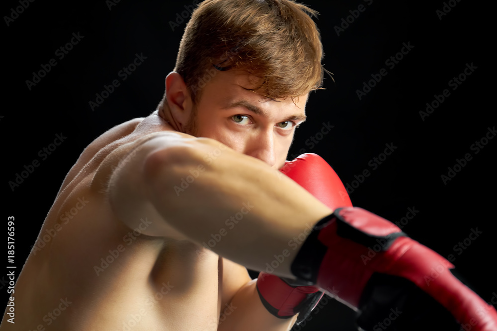 Fighter on a boxing ring. Vigorous sportsman doing offensive and defensive movements. Match, competition concept.