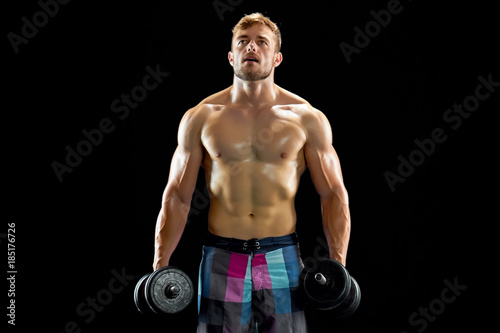 Sportsman with dumbbells. Tired athlete after weightlifting exercises. Result of hard work  sweat and pain.