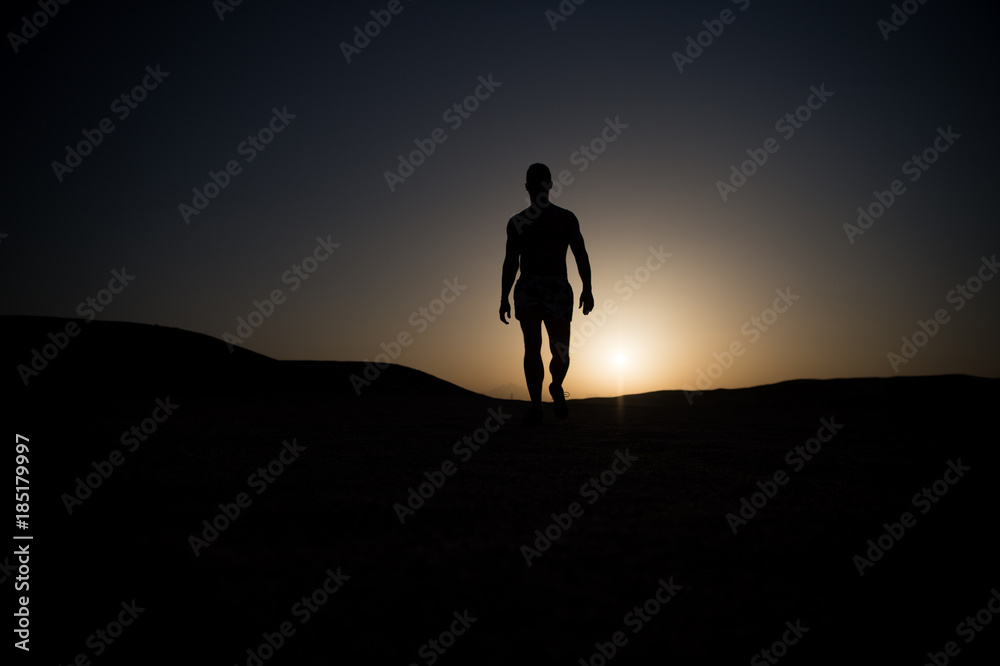 Man walk on sunset sky background.