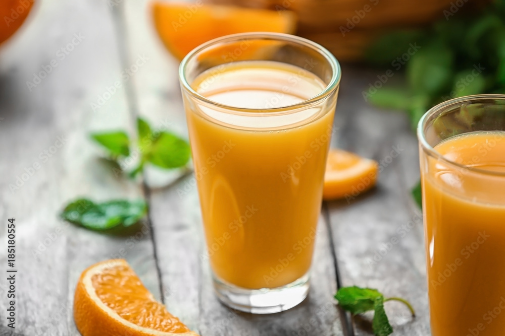 Glasses of fresh orange juice on table