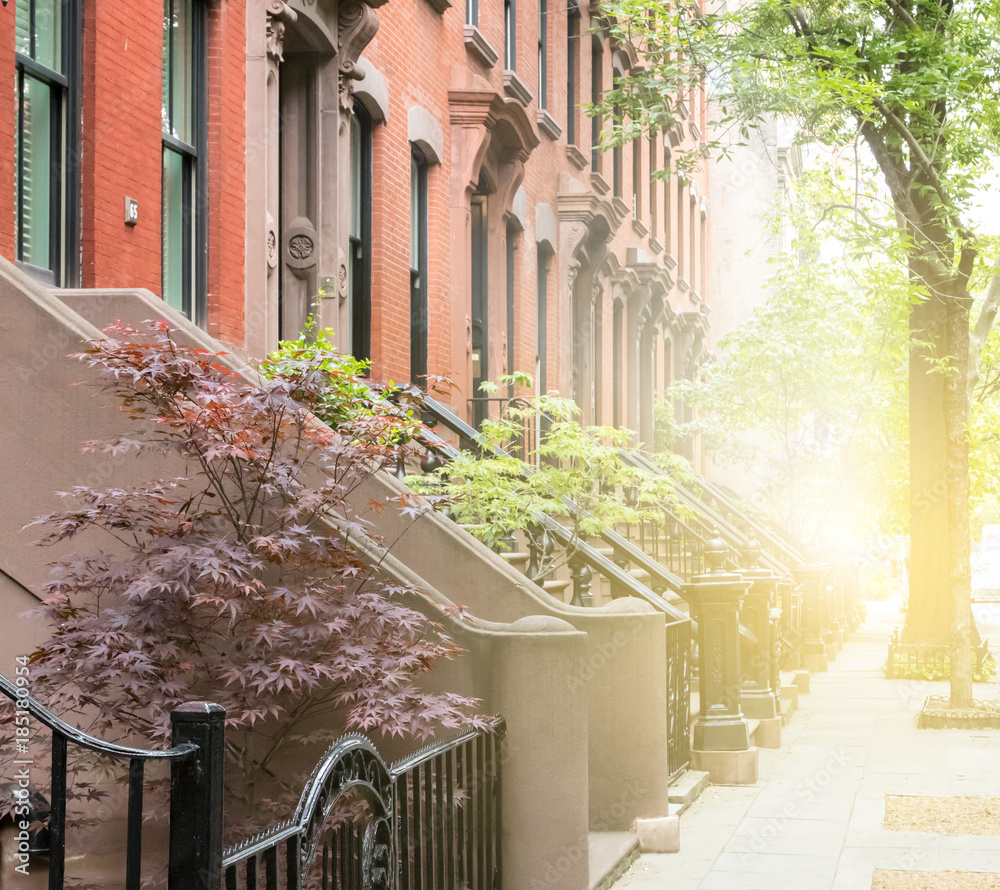 Quiet neighborhood street sidewalk lined with historic brownstone buildings in a Greenwich