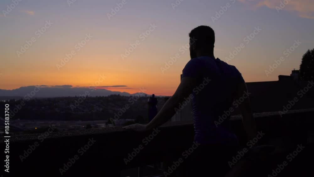 Medium shot of young man stretching in twilight Medium shot of young man stretching in twilight