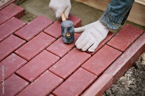 Men paving path using clinker brick