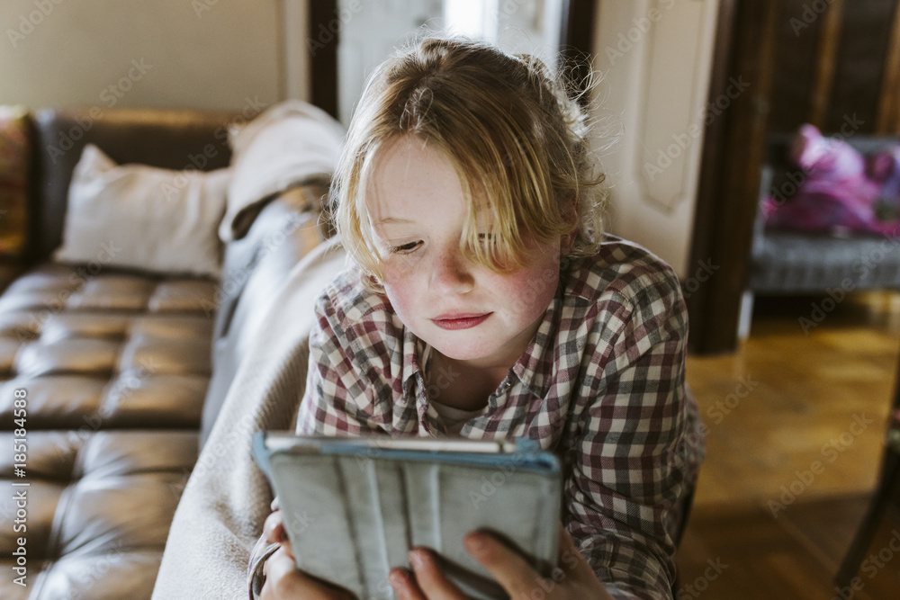 Young girl playing games on tablet at home Young girl playing games on tablet at home