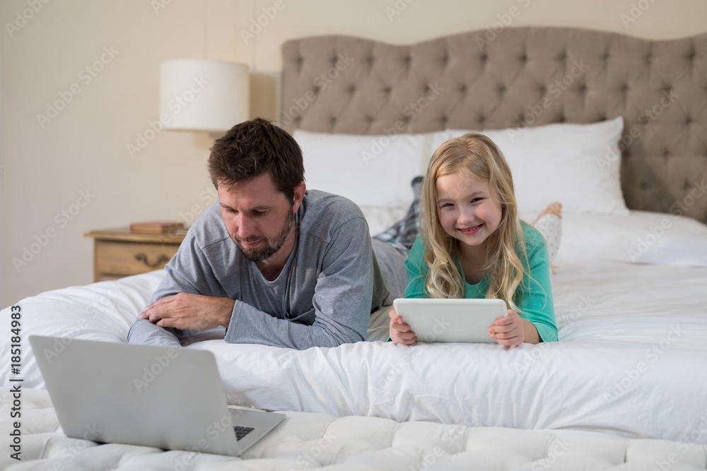 Father and daughter using laptop and digital tablet Father and daughter using laptop and digital tablet