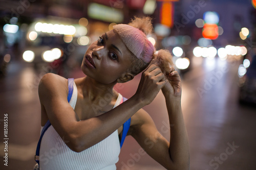 Young woman fixing her hair on the street