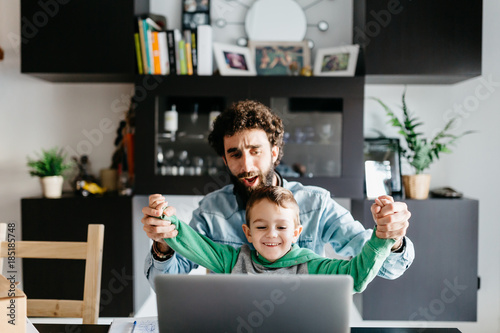 Father and son playing on laptop. photo