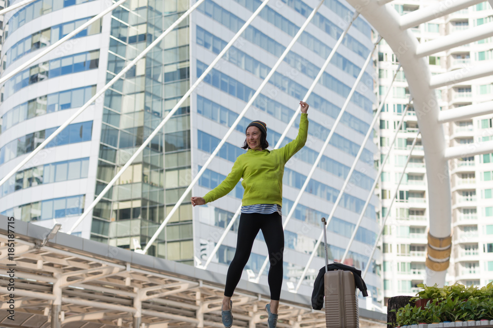 Excited Russian beautiful woman jump raising her arms with luggage travel journey ideas concept. Happy glad woman tourist, vacation holidays, winter traveler Excited Russian beautiful woman jump raising her arms with luggage travel journey ideas concept. Happy glad woman tourist, vacation holidays, winter traveler