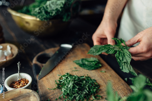 Woman's hands breaking off basil leaves photo