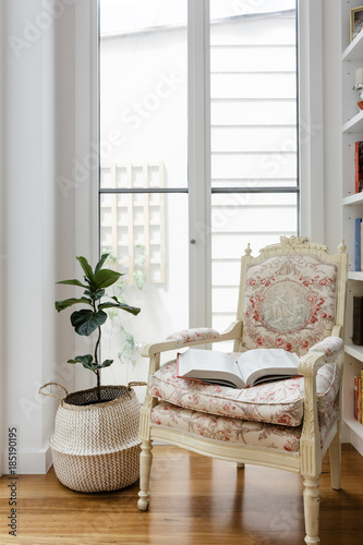 Open book on a comfotable vintage reading chair in a renovated home photo