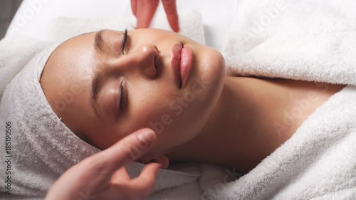 Attractive young woman receiving head massage at spa center.