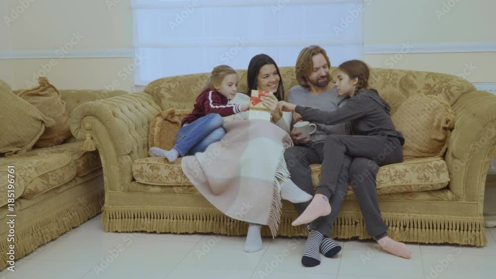 Happy family with christmas gift at the sofa at home Happy family with christmas gift at the sofa at home