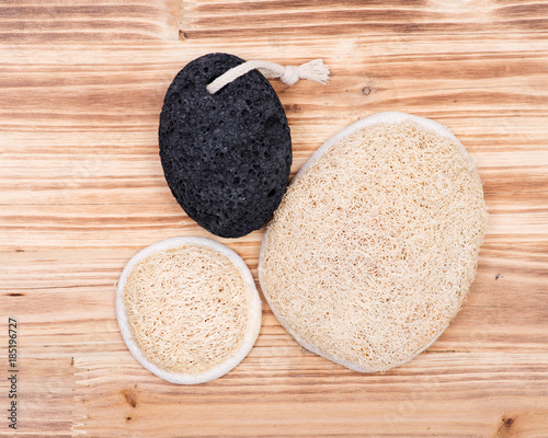 Real volcanic pumice stone and natural loofah sponge on wooden vintage background photo