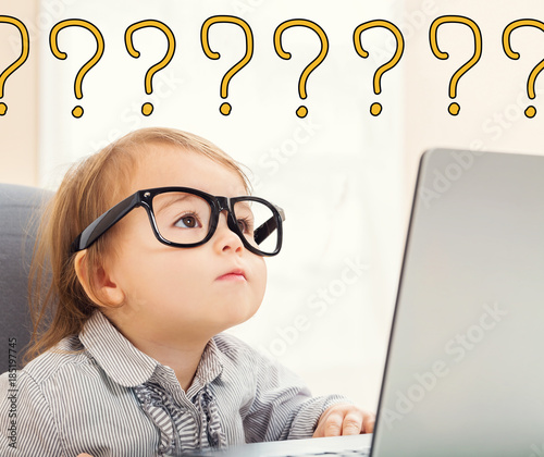 Question Marks text with toddler girl using her laptop