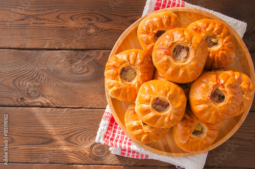 Group of individual pies with meat and potato - vak balish. Tatar traditional pies. Wooden background. Top view. photo