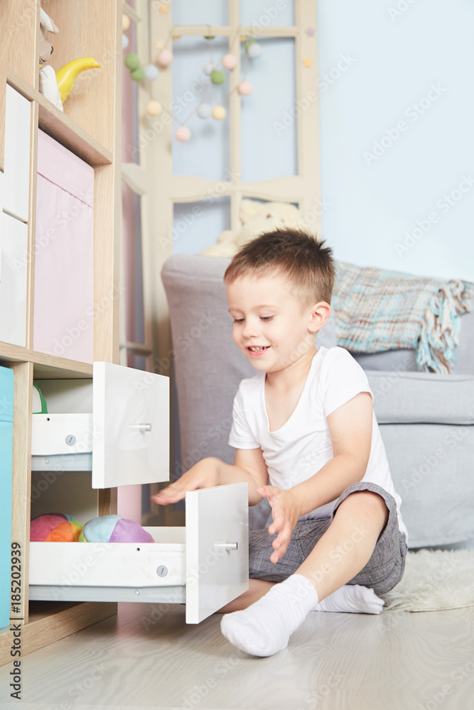 boy in the hands sat on the floor near the wardrobe