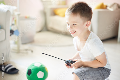a boy playing with a car remote