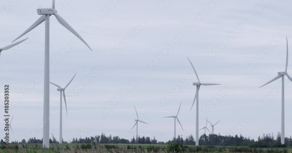 Wind turbines farm in summer - pan slow motion shot Wind turbines farm in summer - pan slow motion shot