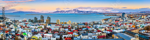 Aerial panorama of downtown Reykjavik at sunset with colorful houses and snowy mountains in the background photo
