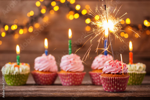 cupcake with sparkler on old wooden background