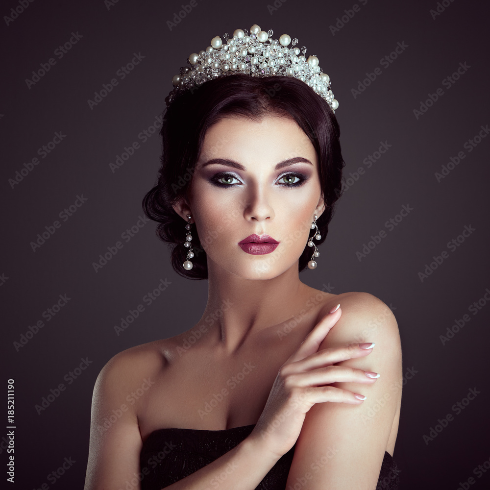 Fashion Portrait of Beautiful Woman with Tiara on head. Elegant Hairstyle. Perfect Make-Up and Jewelry. Red Lips Fashion Portrait of Beautiful Woman with Tiara on head. Elegant Hairstyle. Perfect Make-Up and Jewelry. Red Lips