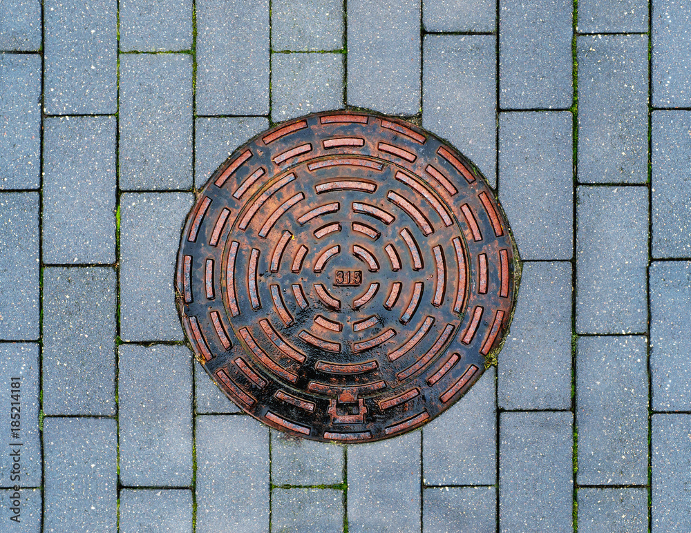 Metal drain cover on the pavement