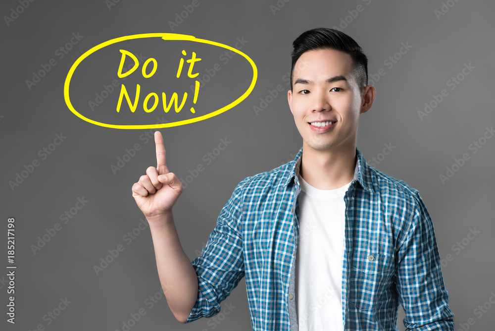 Cheerful young Asian man pointing to Cheerful young Asian man pointing to
