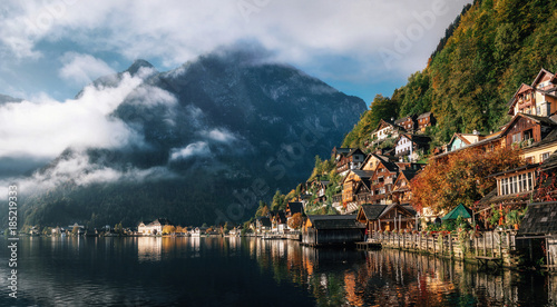Scenic view of famous Hallstatt lakeside town reflecting in Hallstattersee lake in the Austrian Alps in morning light in autumn with clouds, Salzkammergut region, Austria © bortnikau