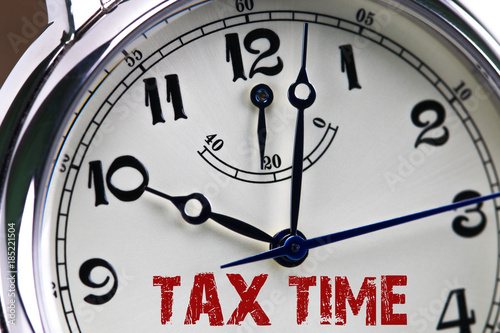 tax time concept clock closeup isolated on white background with red words