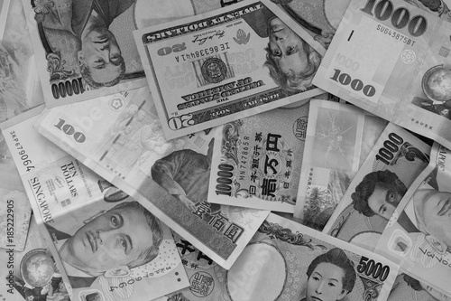 Different International money banknotes bills stacked background with black and white color filter