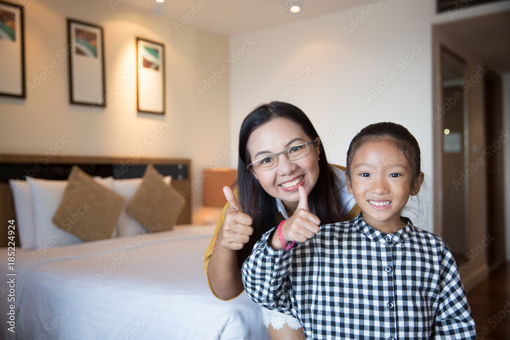 Mother and daughter enjoy relaxing in the hotel bed room on holiday Mother and daughter enjoy relaxing in the hotel bed room on holiday