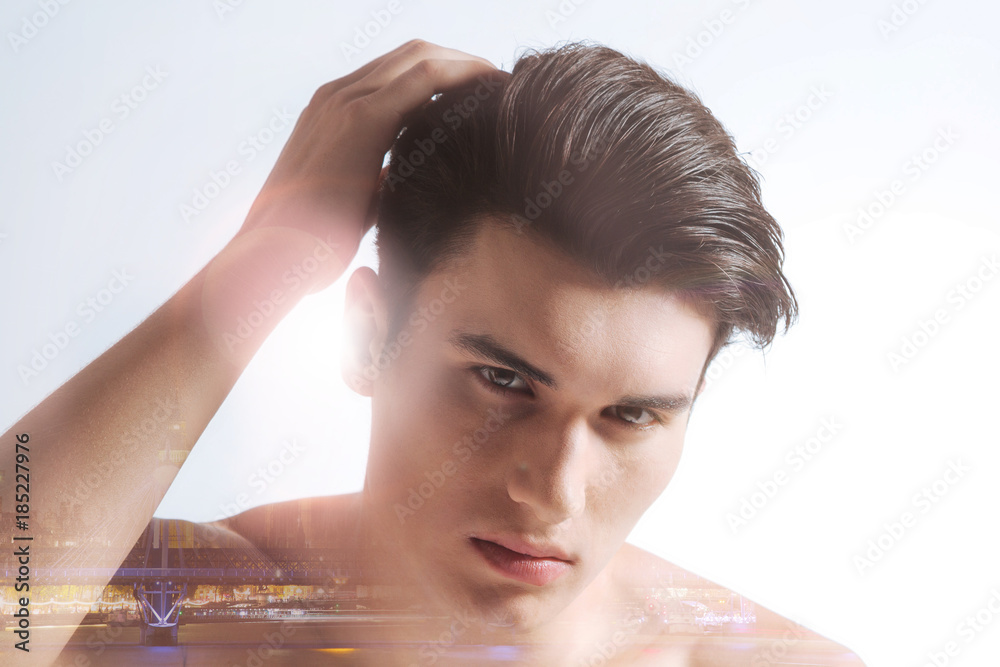 Naklejka premium Seriousness and confidence. Portrait of nice handsome man touching his hair while showing his confidence