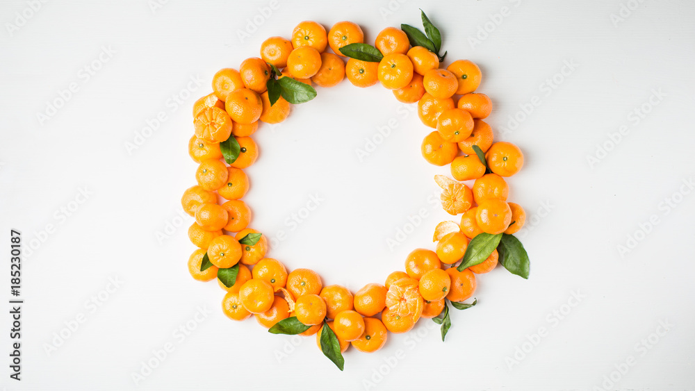 Φωτογραφία Christmas  tangerine mood!) Wreath made of  fresh small tangerines and green leaves on white wooden background