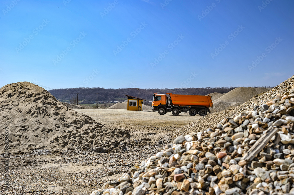 Gravel excavation site in a sunny day industrial machines.