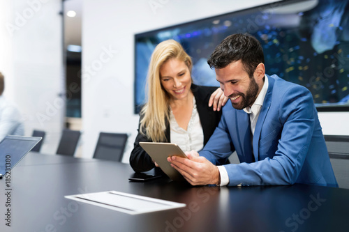 Attractive business couple using tablet in their company