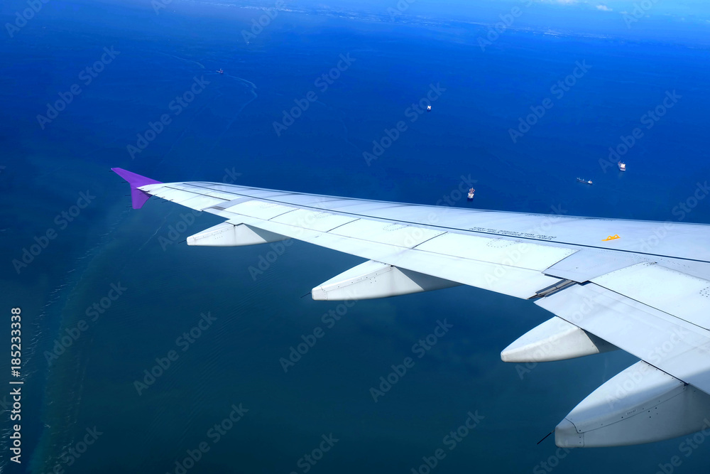 Obraz premium view from aircraft fly over the sea, aircraft Wing and ship with Blue sea