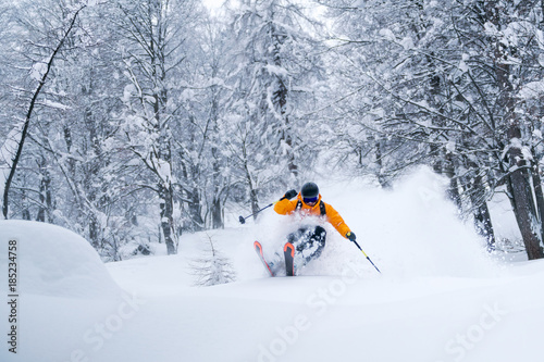 A male skier is riding in fresh powder snow at the Gosau valley in Austria.