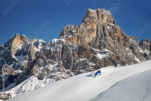 A skier does action skiing at the Rolle Pass in the Dolomites, Italy.