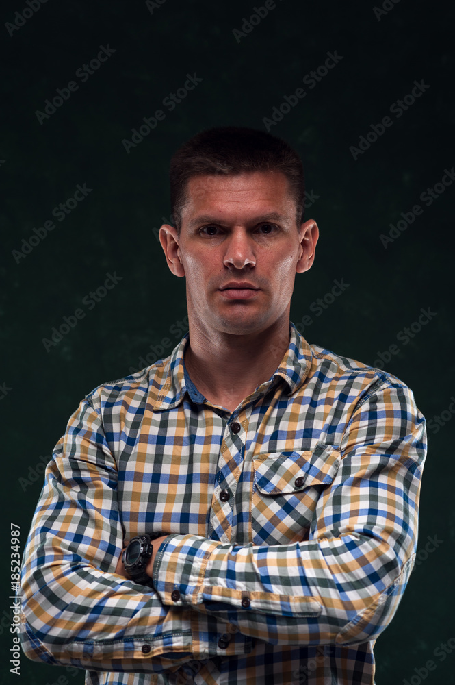 Portrait of confident man in plaid shirt on green vintage background. Portrait of confident man in plaid shirt on green vintage background.