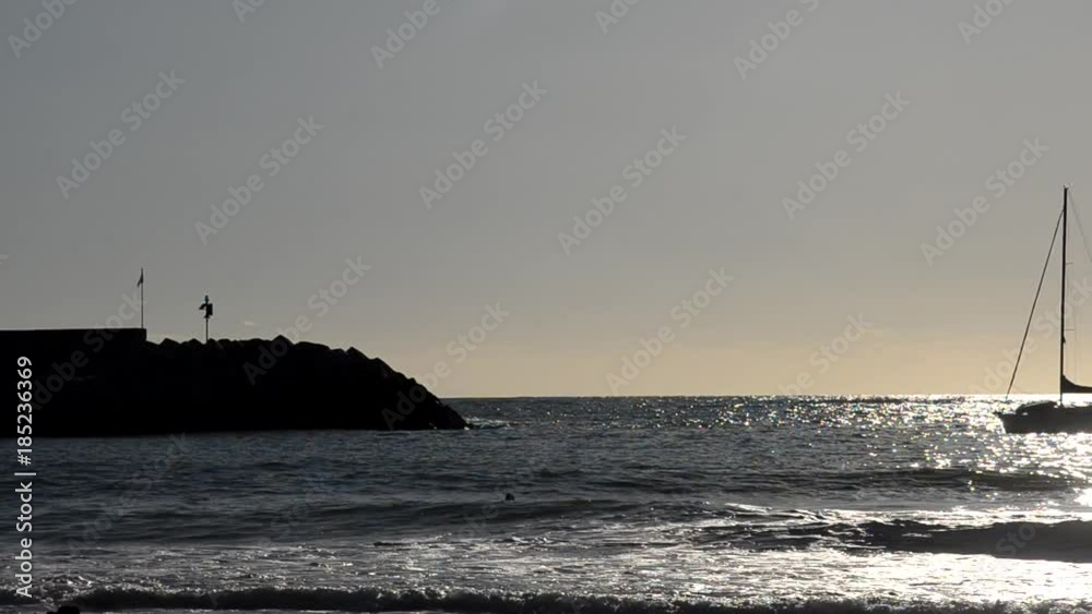 Boat enters at port while man surfs